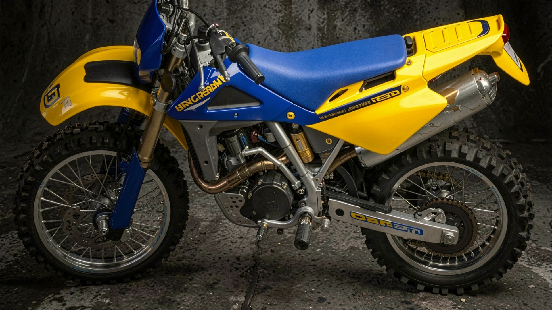 Мотоцикл эндуро сине-желтого цвета в гараже