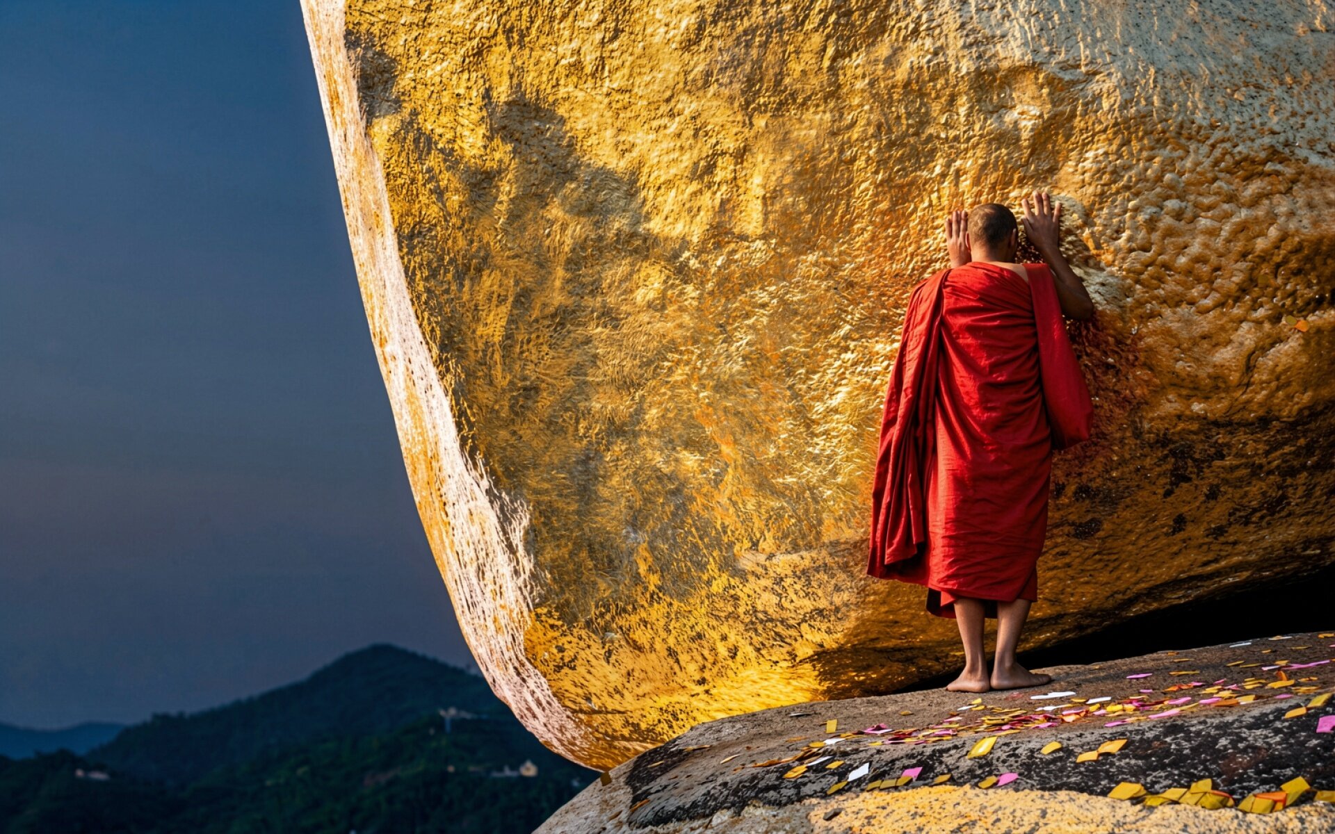 Золотой камень с буддийским монахом в красном