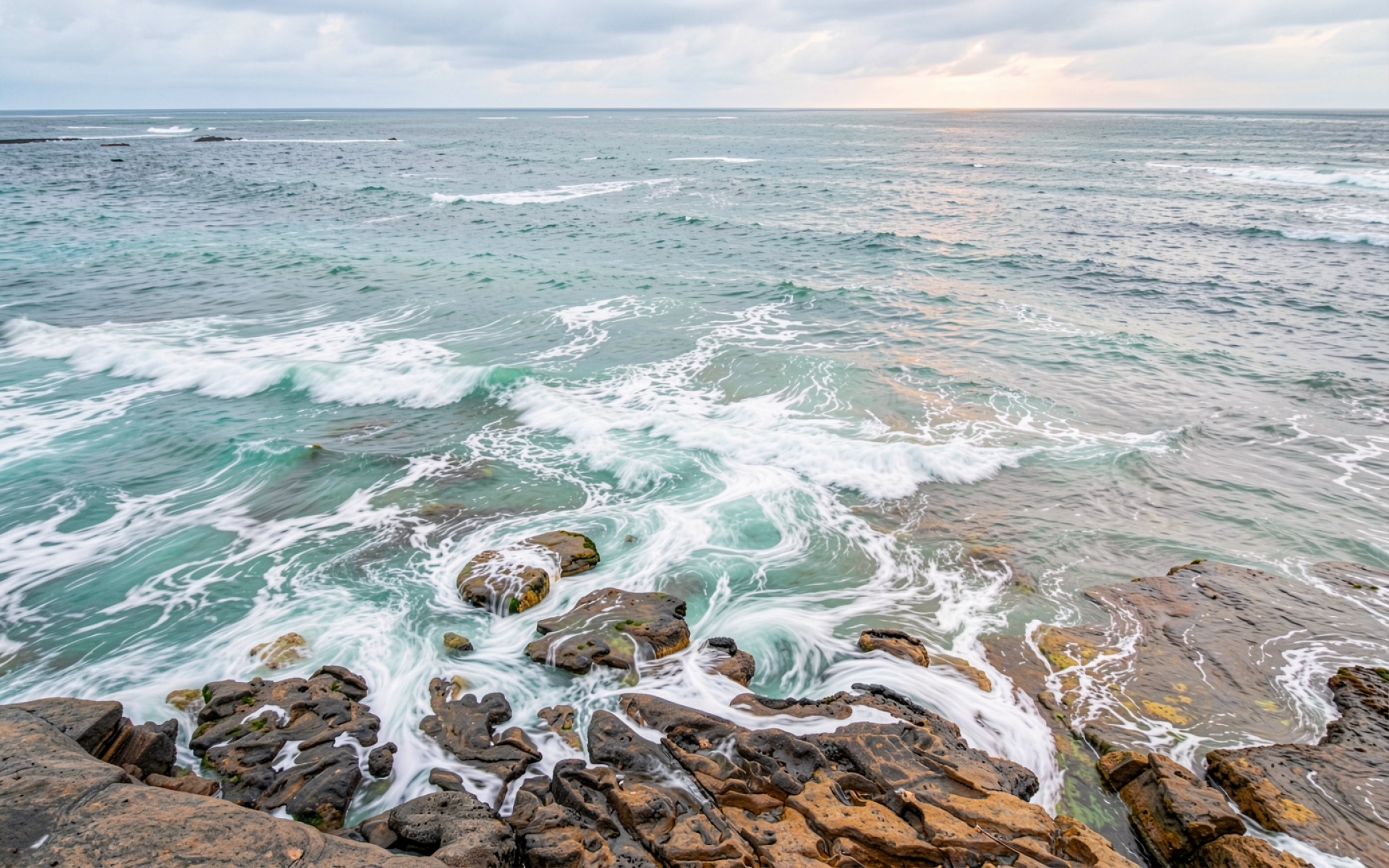 Морской прибой на скалистом берегу в сумерках