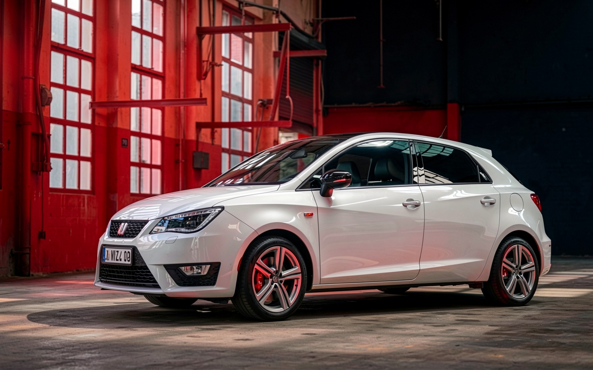 Белый автомобиль Seat Ibiza в красном ангаре