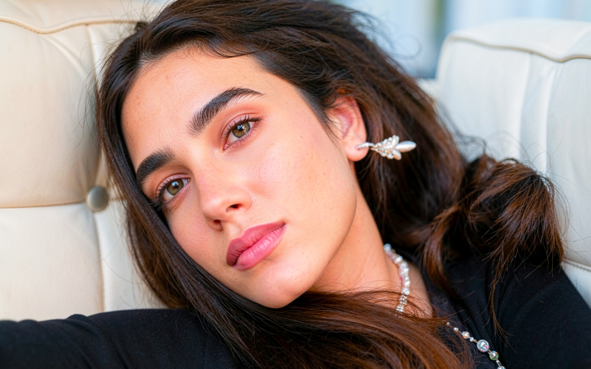 Девушка с карими глазами в белом кресле