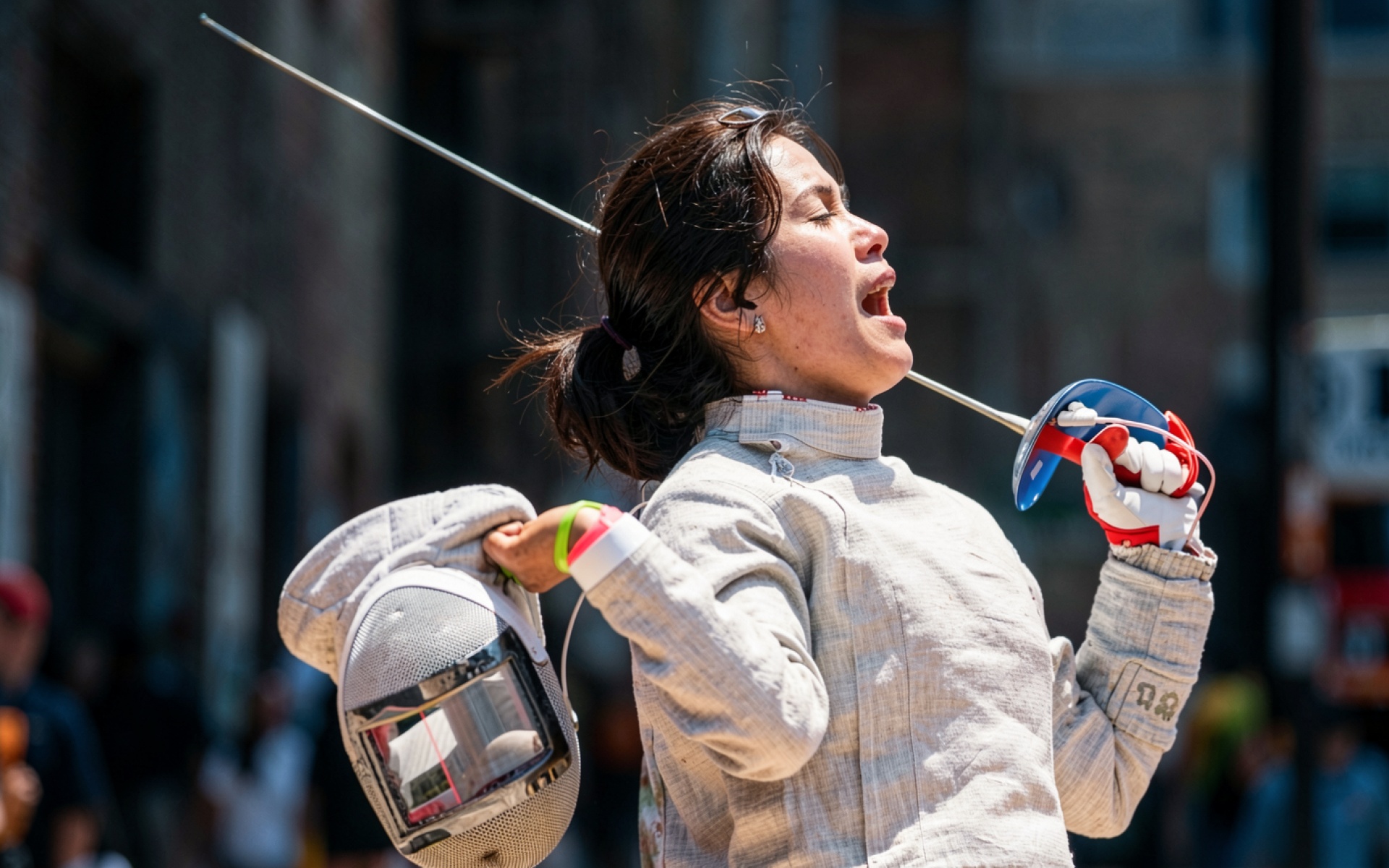 Фехтовальщица в белом костюме с рапирой