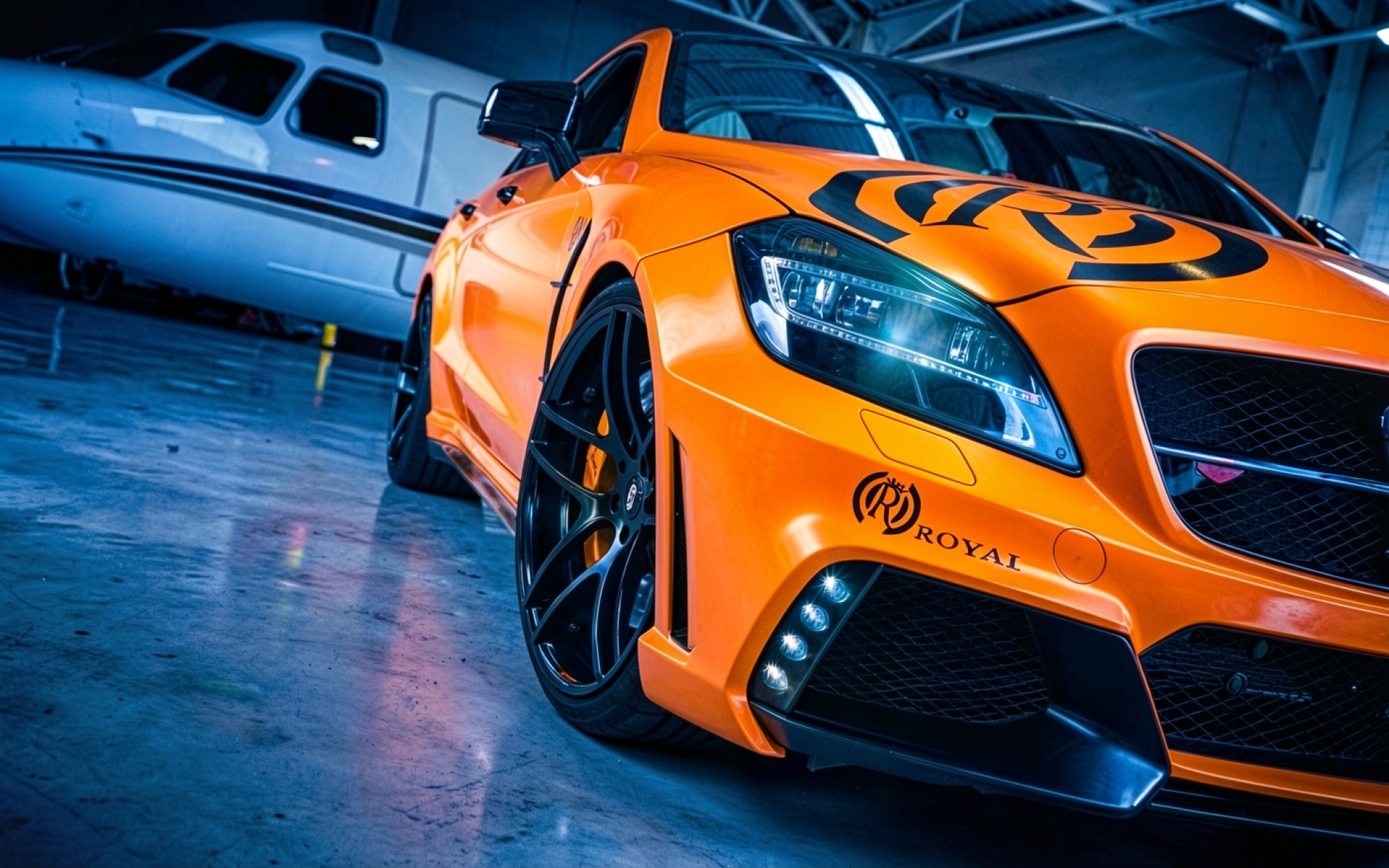 Оранжевый автомобиль Royal в темном авиационном ангаре