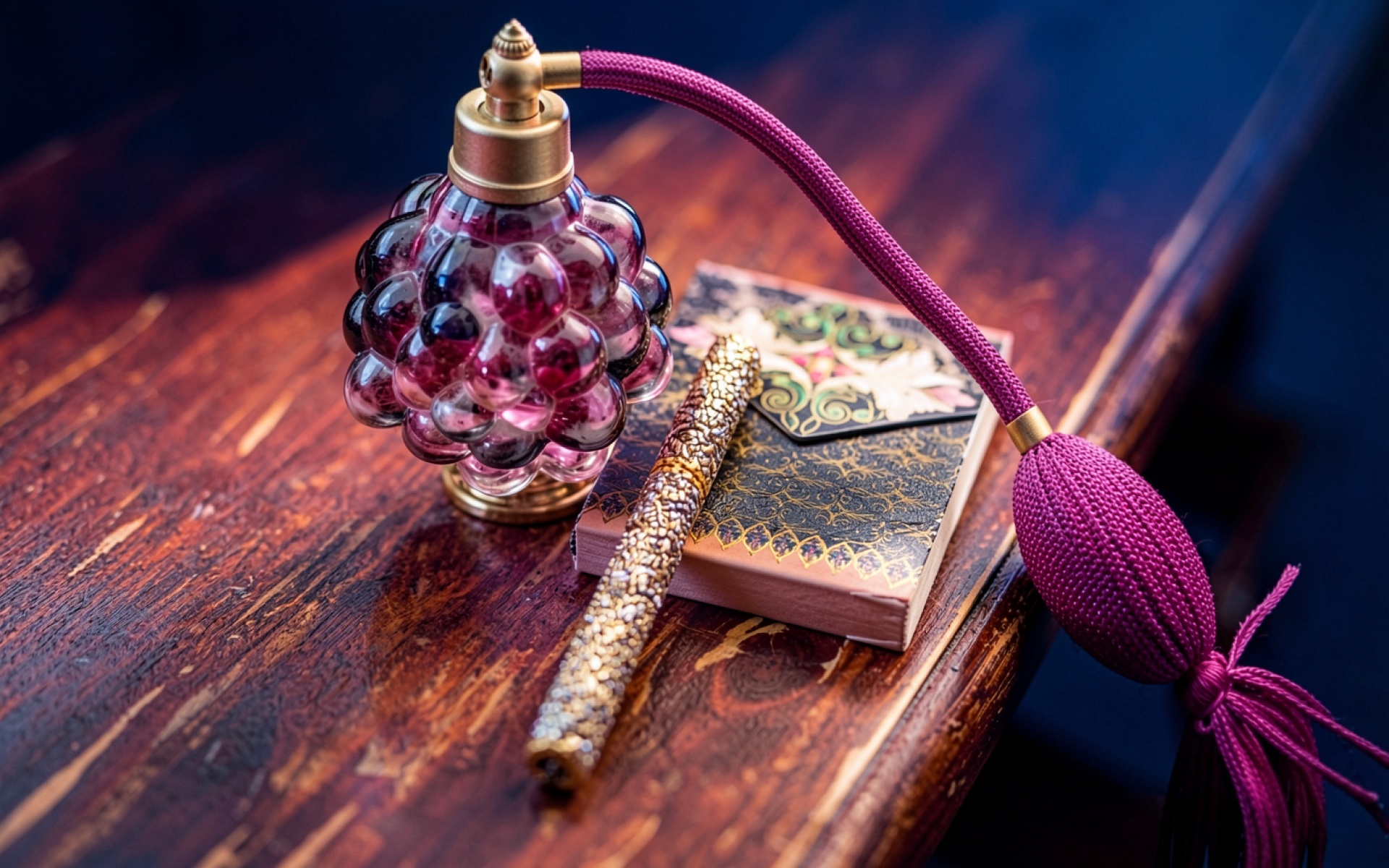 Стеклянный флакон духов пурпурного цвета на столе