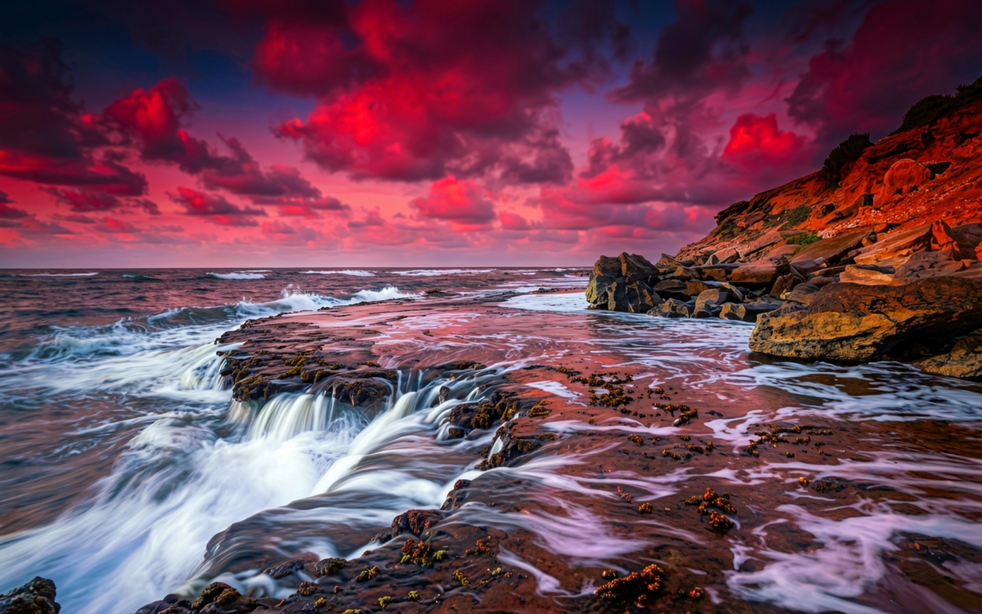 Берег океана с красным закатным небом