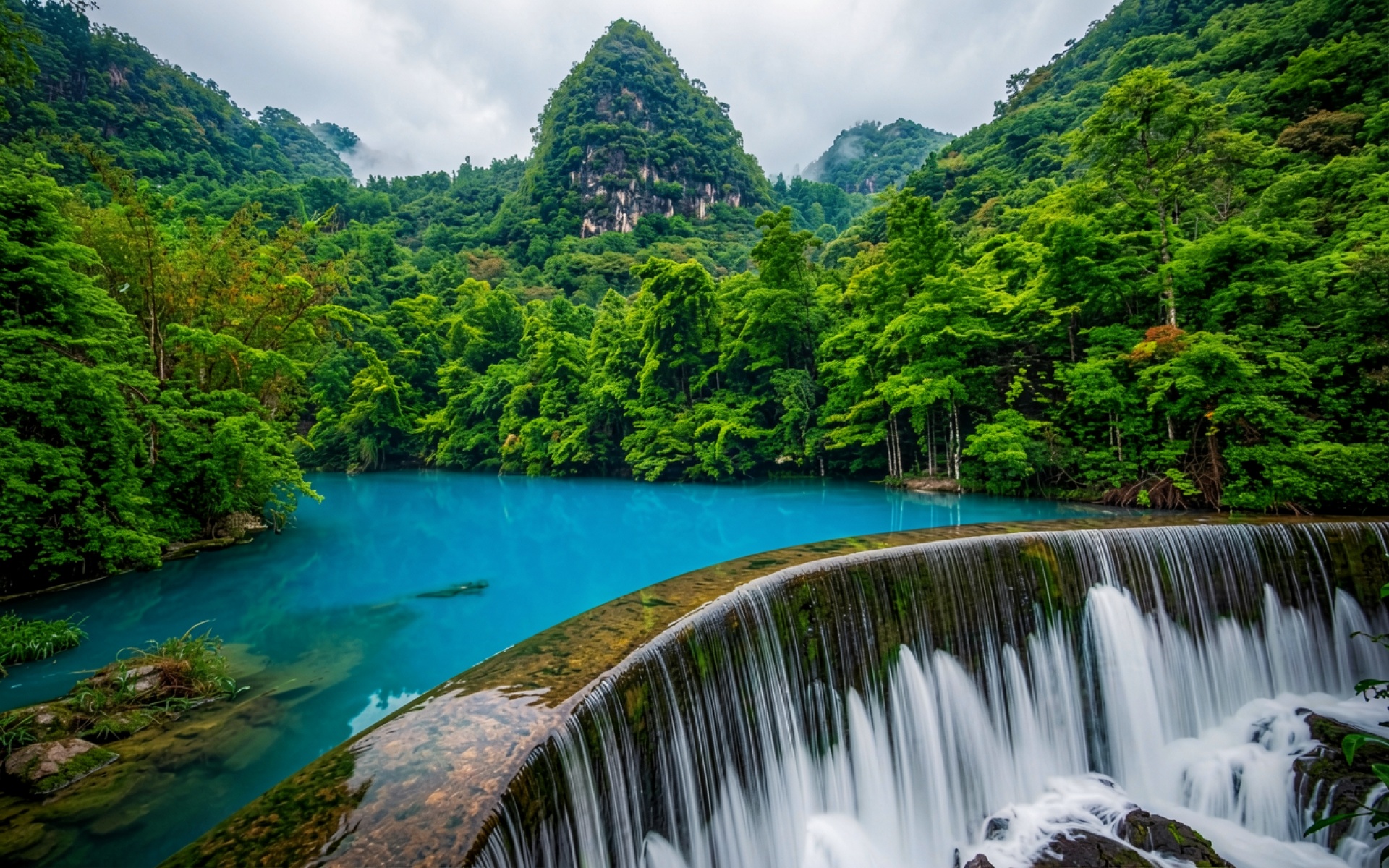 Голубое озеро с водопадом в тропическом лесу