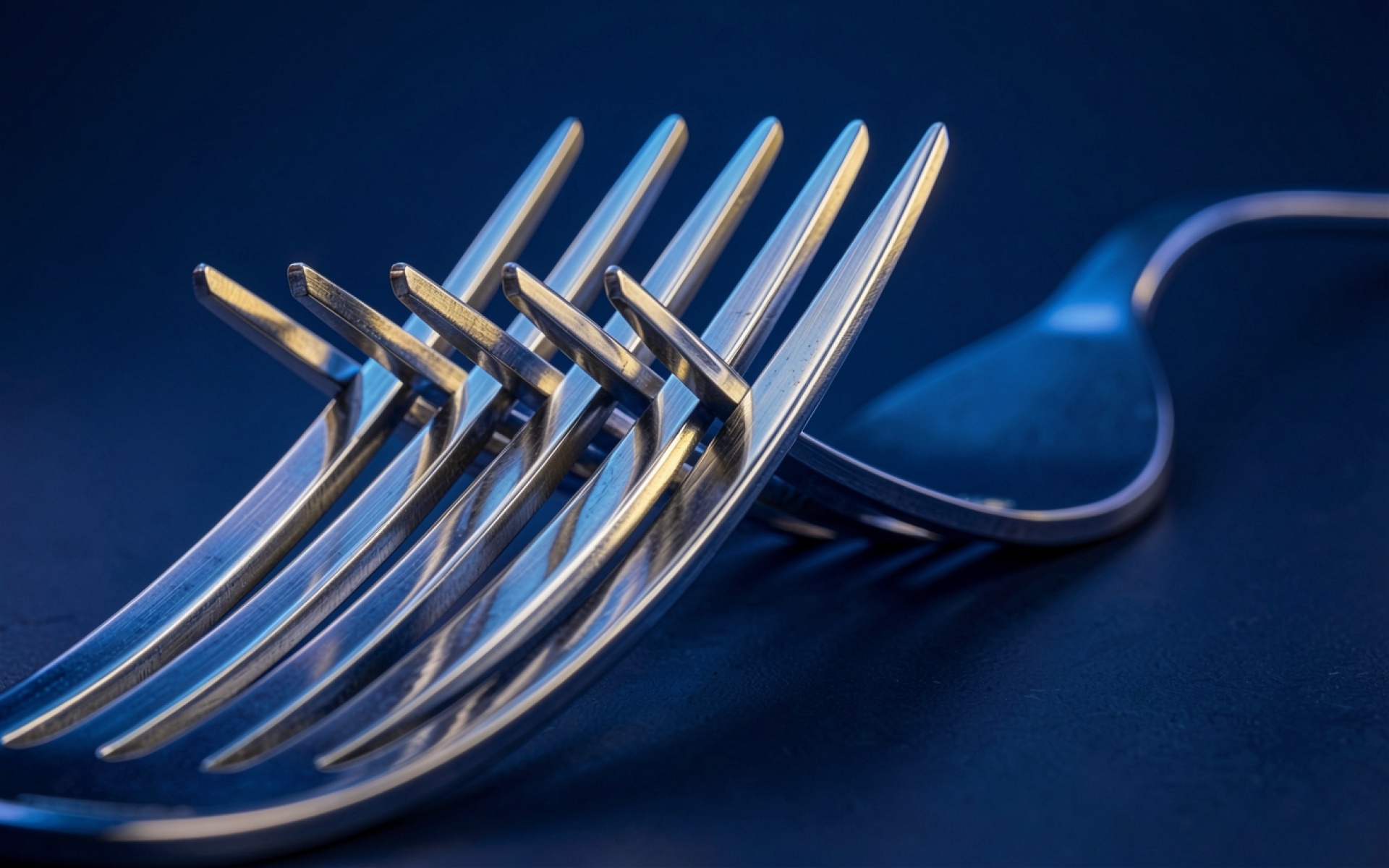 Металлические вилки в синем неоновом освещении