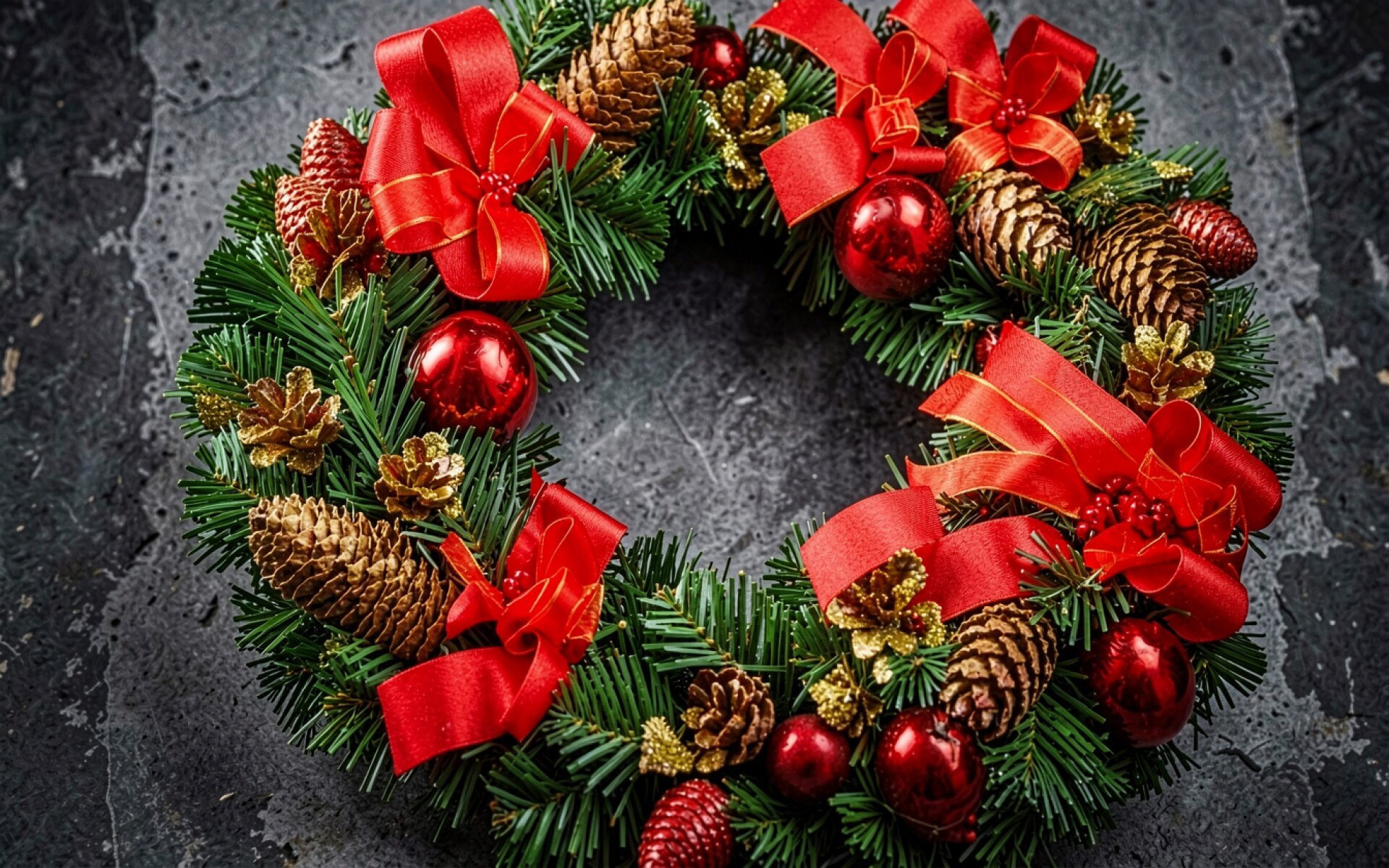 Рождественский венок с красными бантами и шишками
