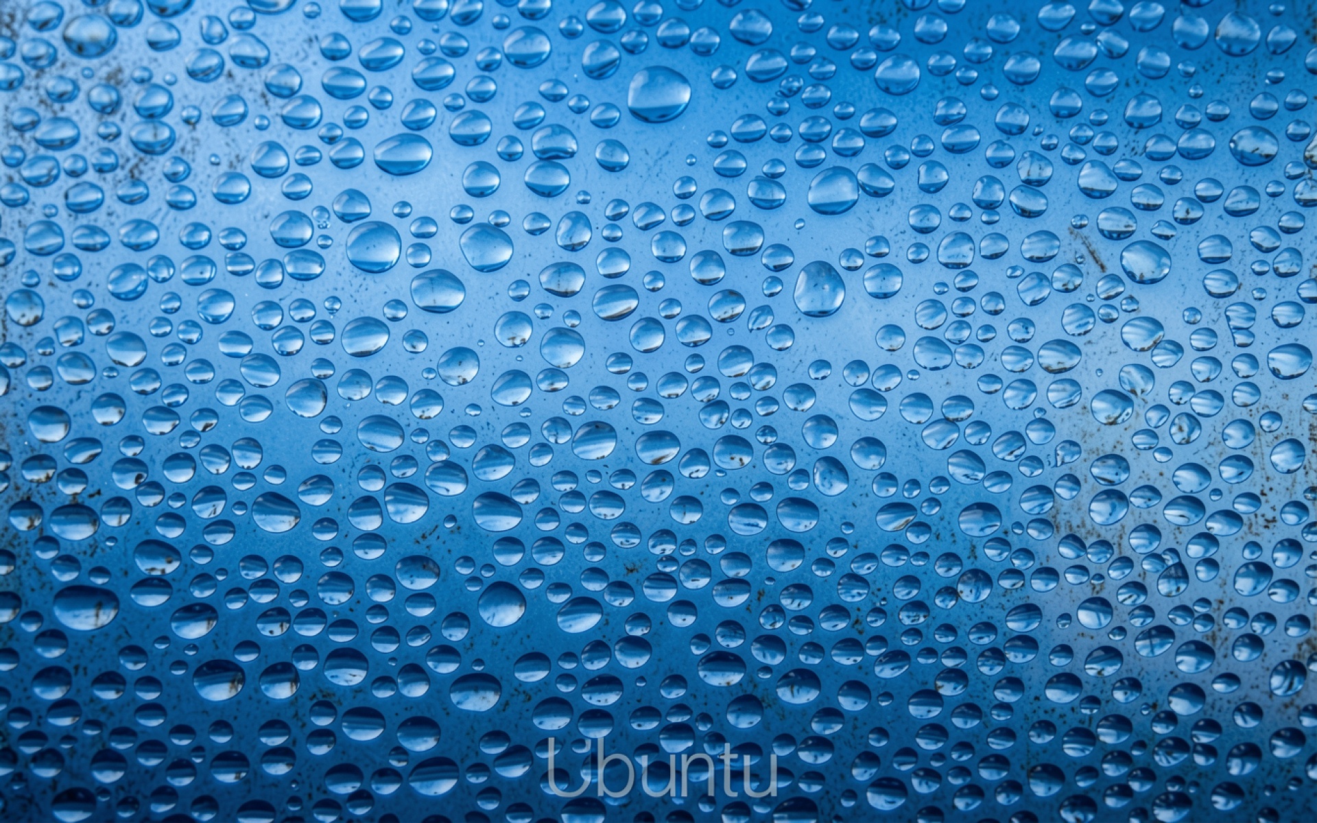 Капли воды на синем металлическом фоне