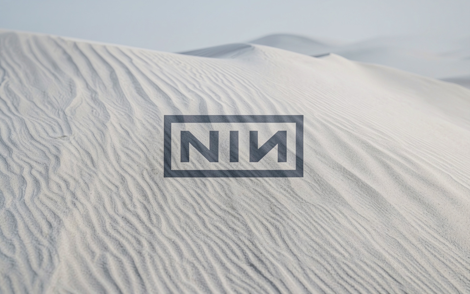 Логотип NIN на белых песчаных дюнах