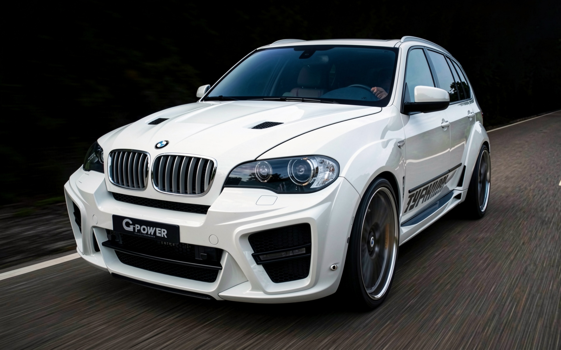 Белый тюнингованный BMW X5 в динамике на дороге