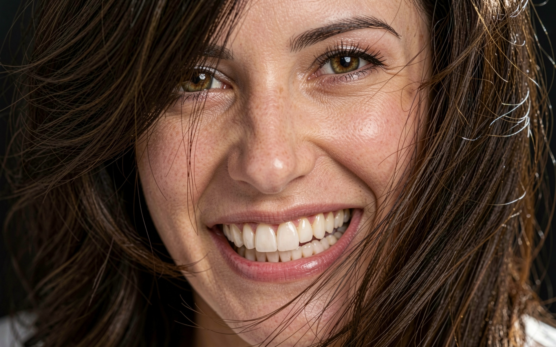 Портрет улыбающейся девушки с веснушками крупным планом