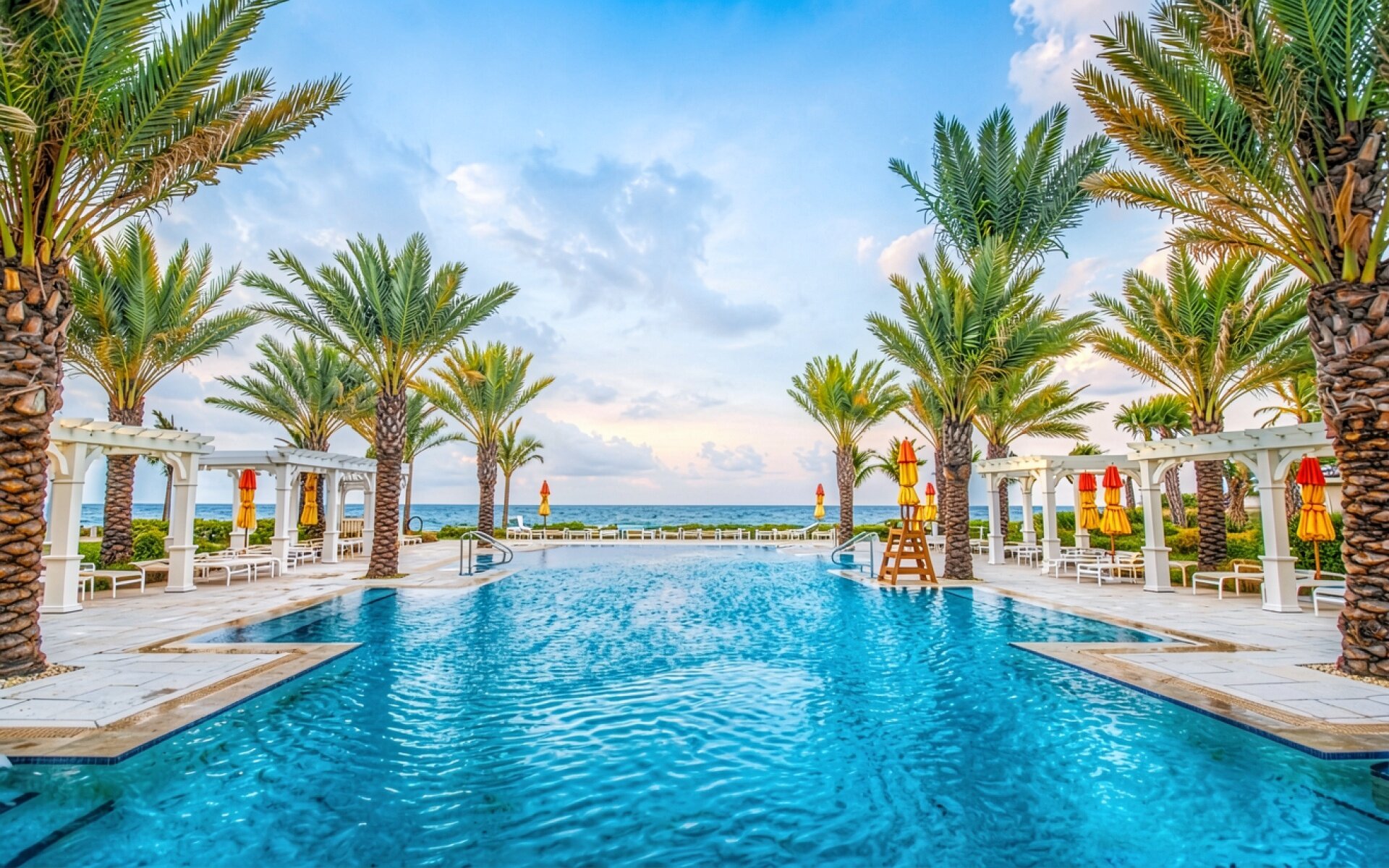 Голубой бассейн с пальмами в тропическом курорте