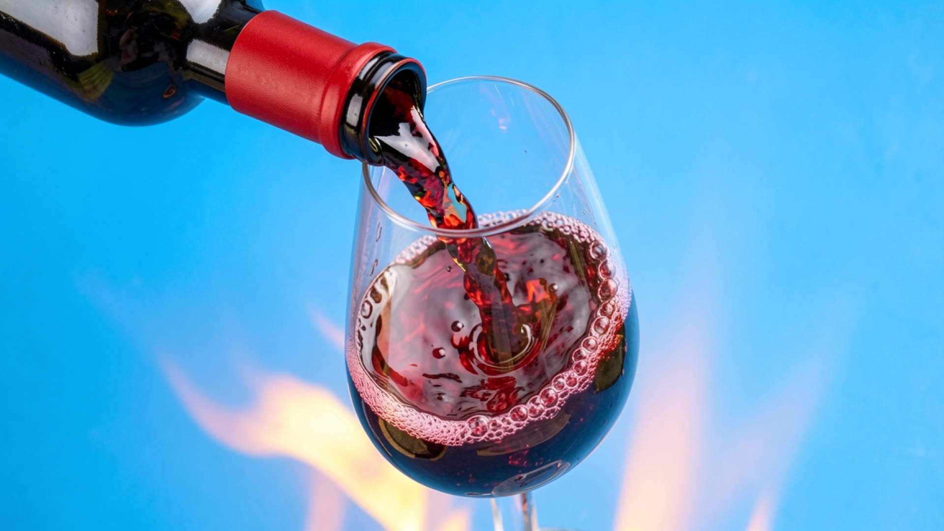 Красное вино в бокале на синем фоне