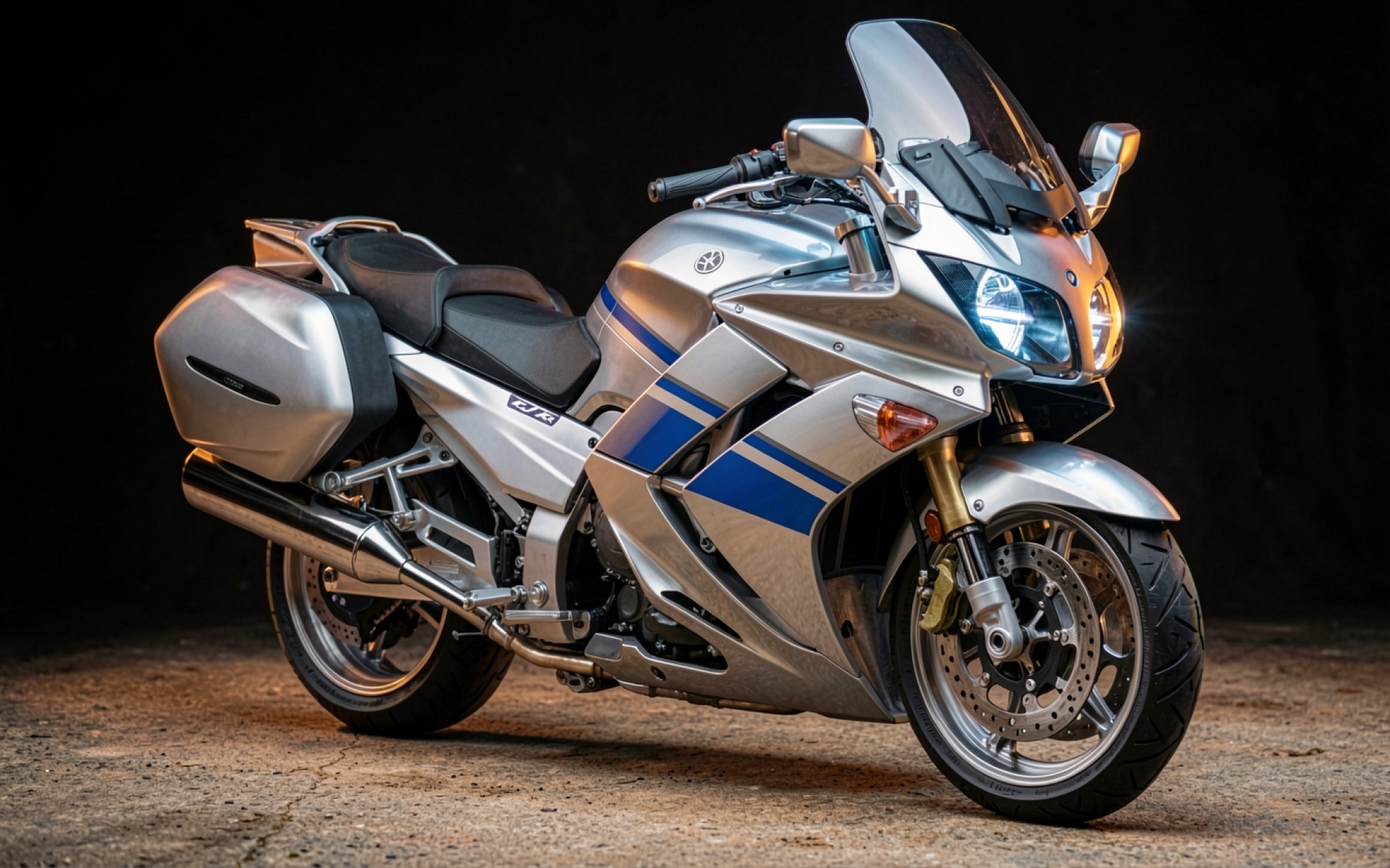 Серебристый мотоцикл Yamaha FJR1300 в темной студии