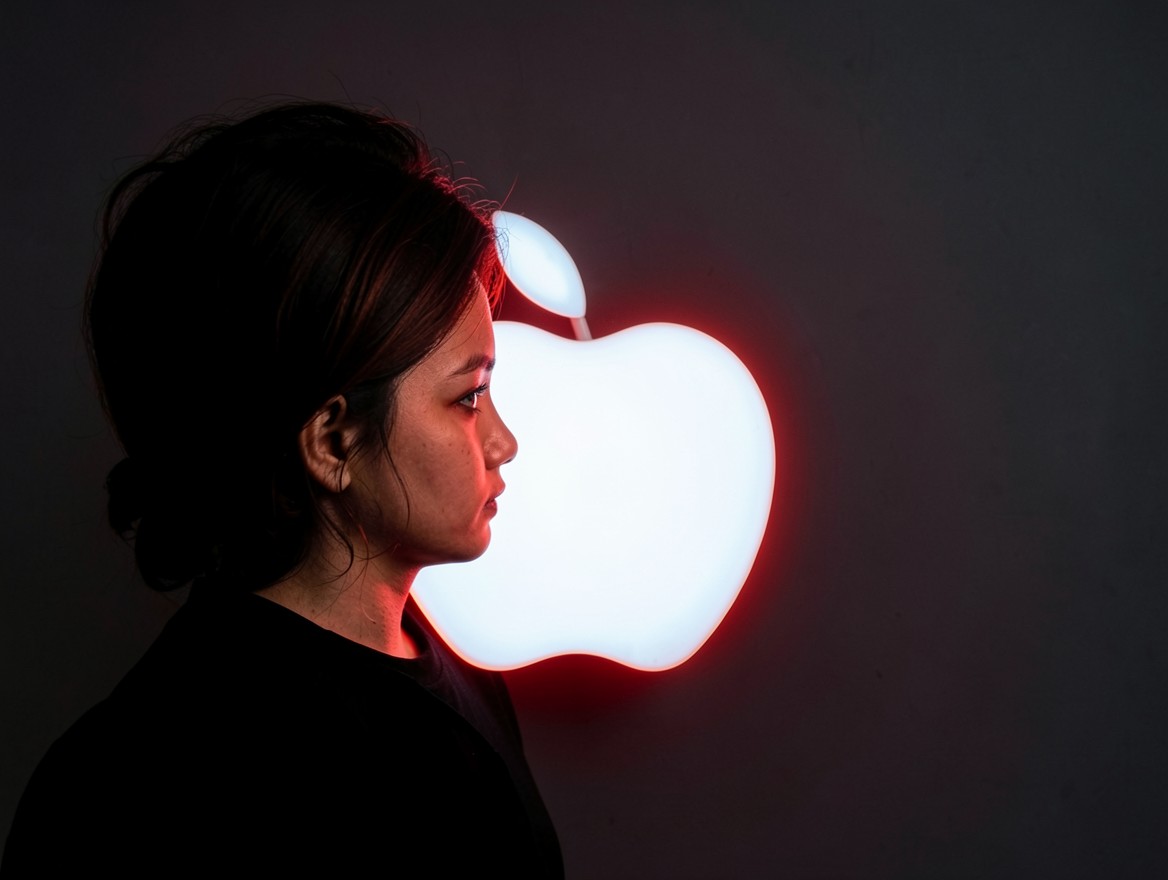 Профиль девушки на фоне светящегося логотипа Apple