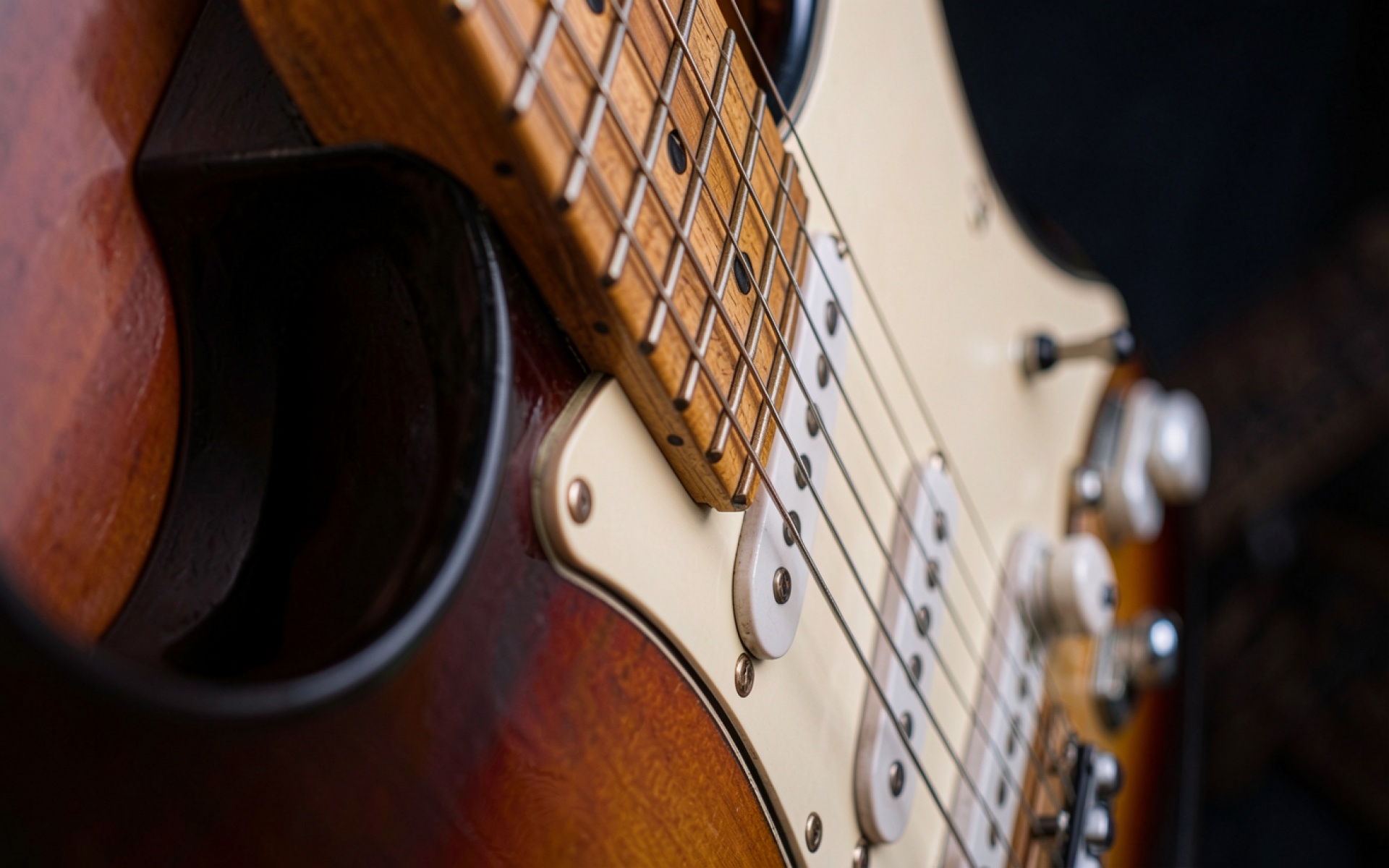 Электрогитара Stratocaster коричневого цвета в студийном освещении