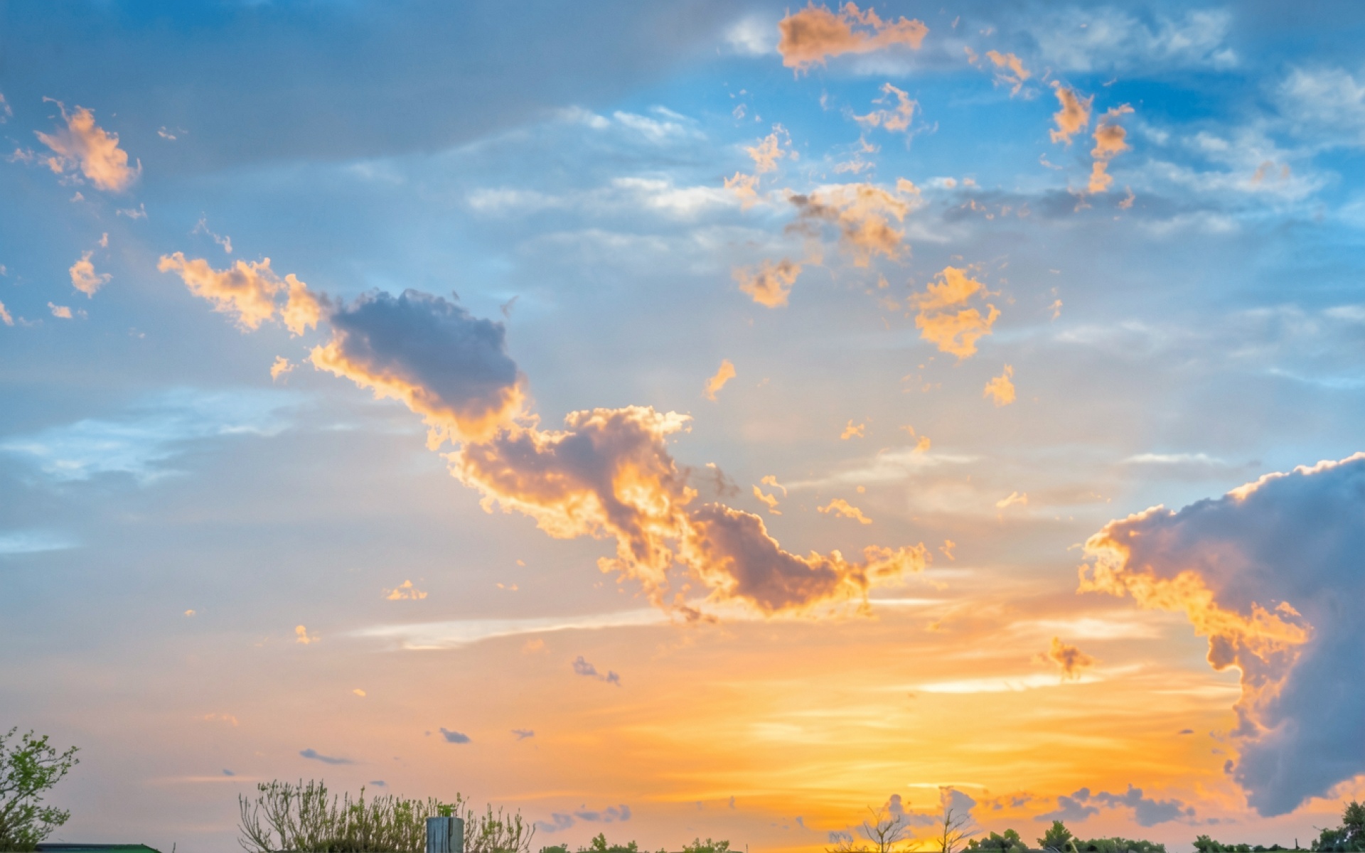 Закат в голубом небе с золотистыми облаками