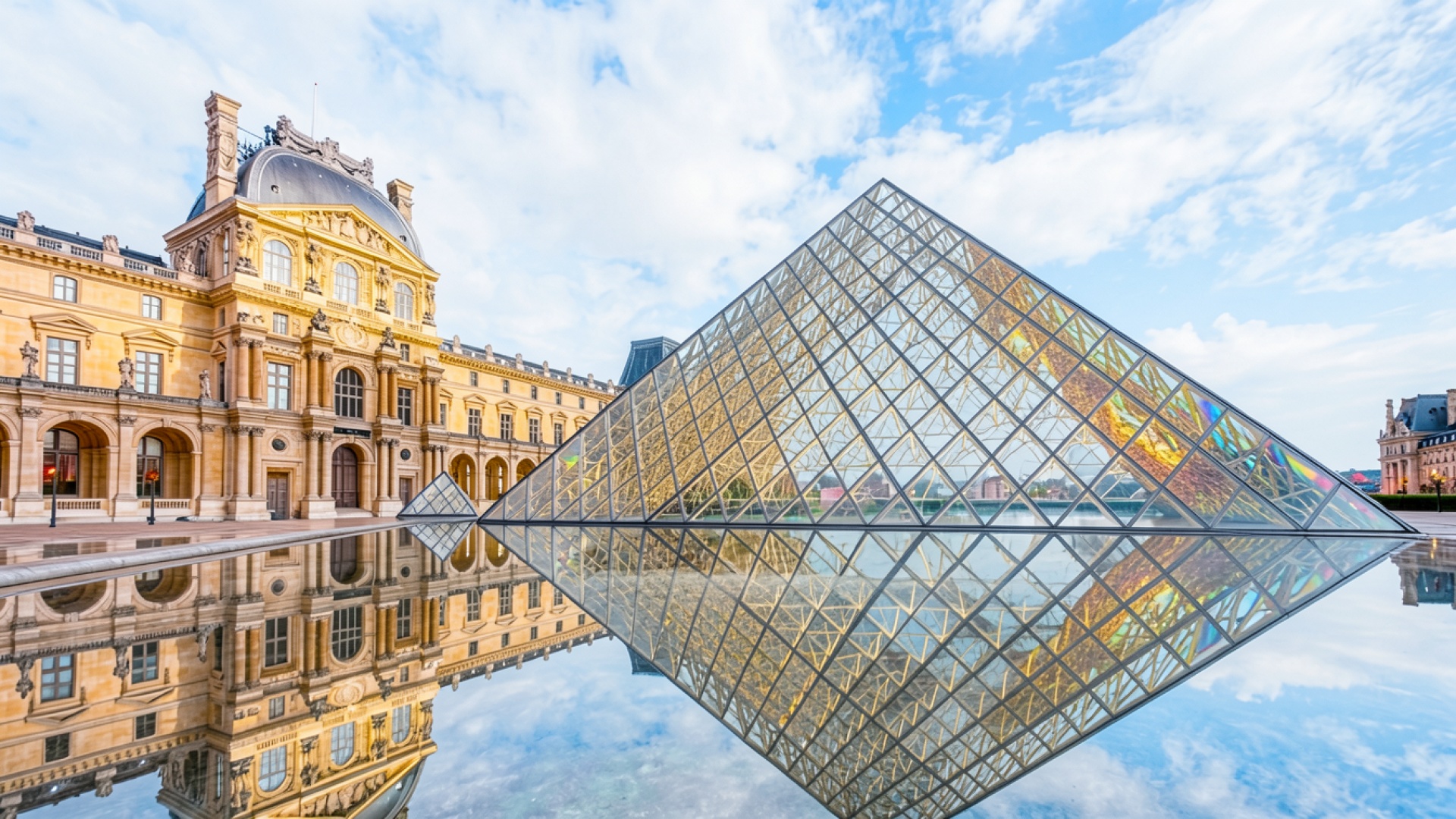 Стеклянная пирамида Лувра в дневном солнечном свете