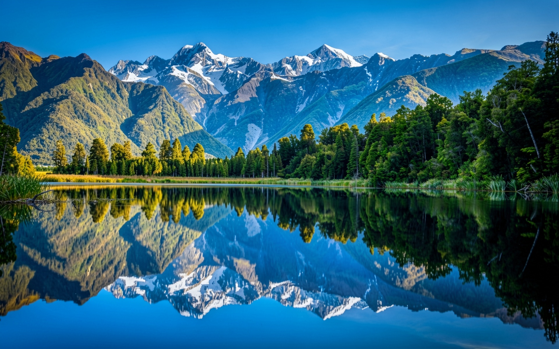 Снежные горы над озером в солнечный день