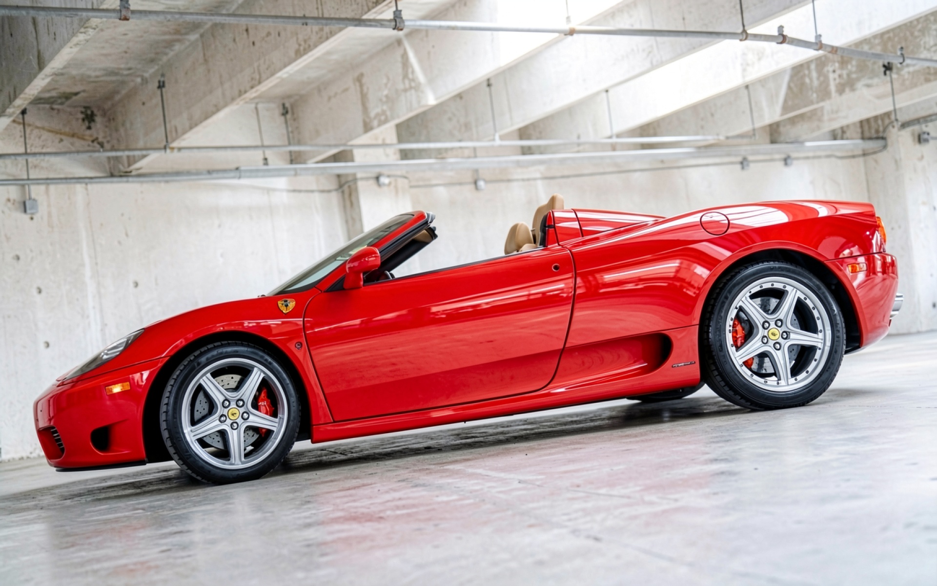 Красный спорткар Ferrari в бетонном гараже