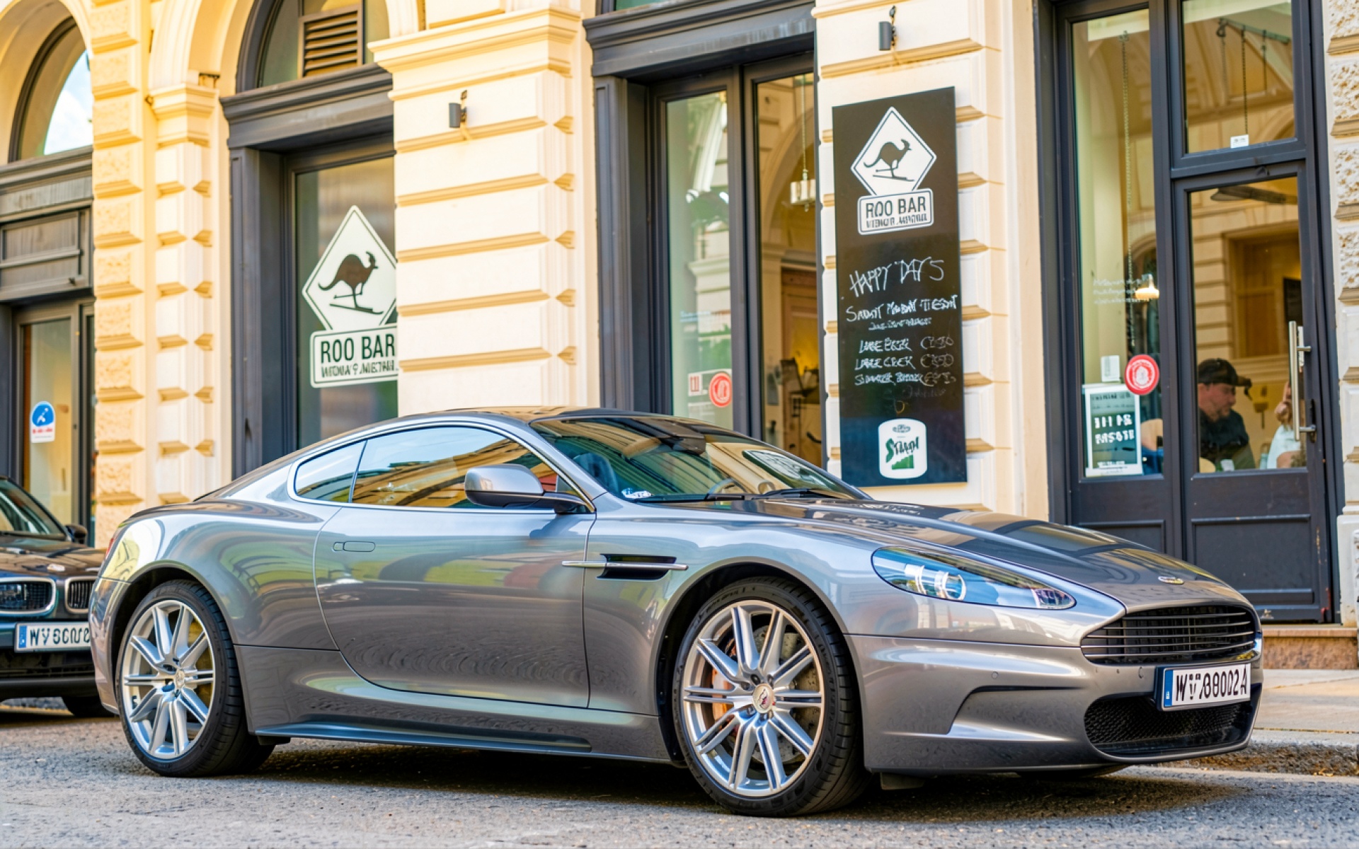 Серый автомобиль Aston Martin на городской улице