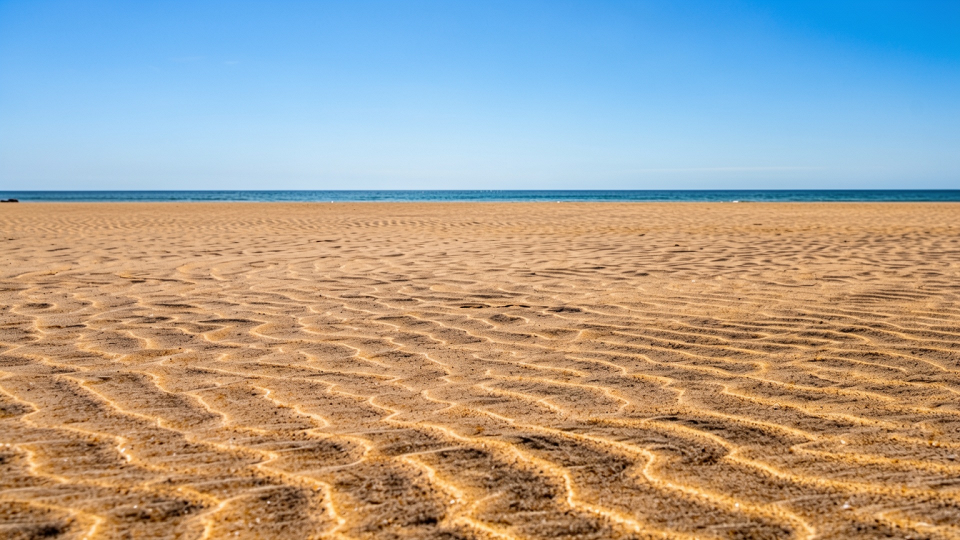 Золотистый песчаный пляж под ярко синим небом