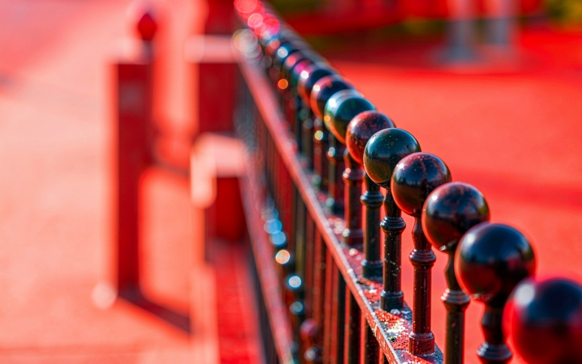 Черный металлический забор на красном фоне