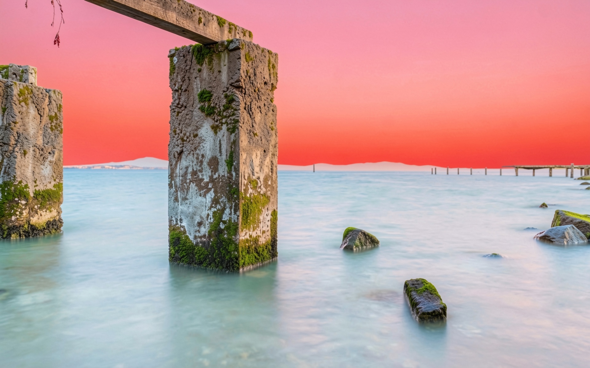 Бетонные опоры пирса в красном закатном небе